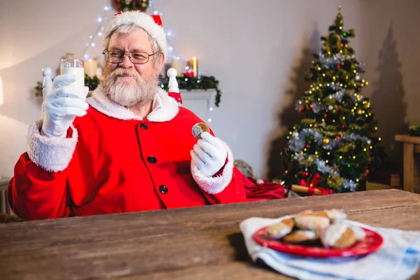 Kerstman met cookie met glas melk — Stockfoto