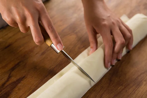 Mujer rebanando masa en la tabla de cortar — Foto de Stock