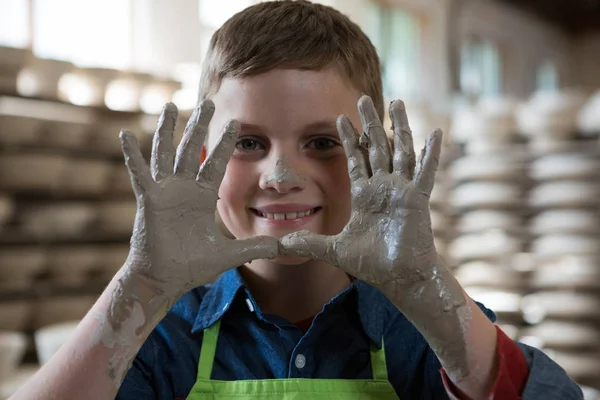 Boy ukazující jíl ruce v porcelánu — Stock fotografie