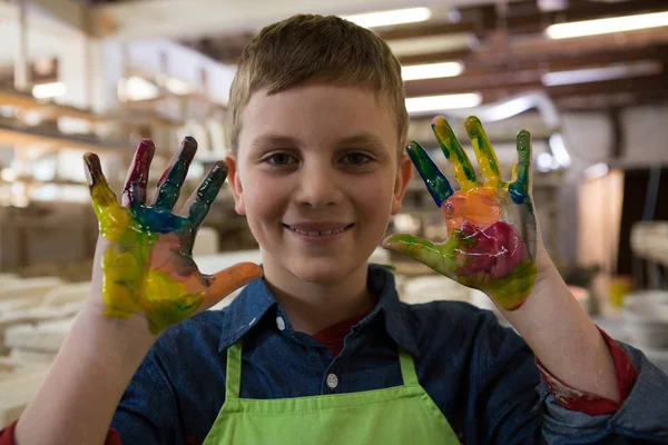Menino mostrando tinta colorida nas mãos — Fotografia de Stock
