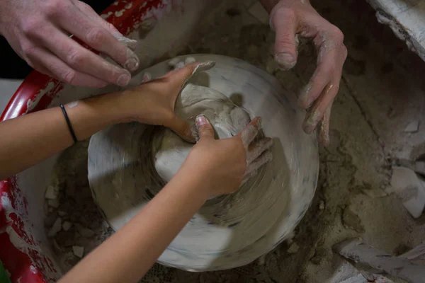 Mannelijke potter dochter bijstaan in het maken van de pot — Stockfoto