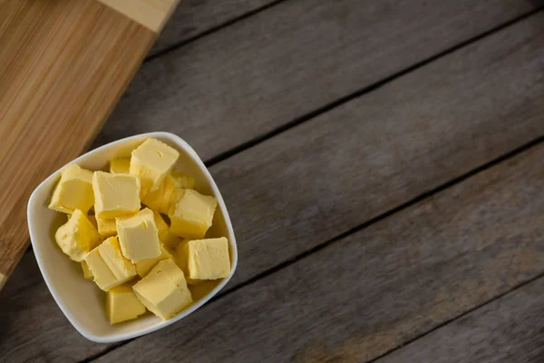 Cubos de queso en un tazón sobre una mesa de madera — Foto de Stock