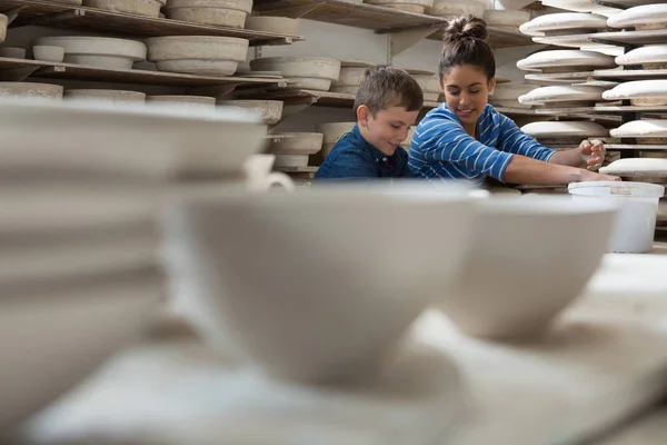 Female potter assisting a boy — Stock Photo, Image