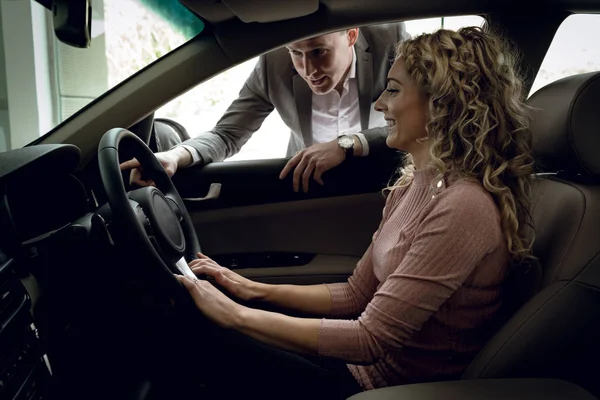 Verkäufer hilft Kundin im Auto — Stockfoto