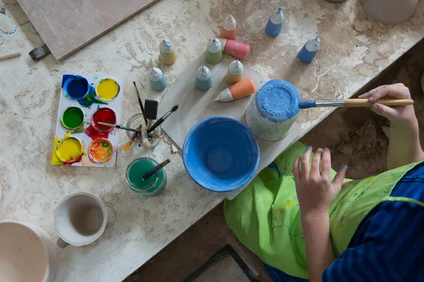 Menino pintando uma tigela na loja de cerâmica — Fotografia de Stock
