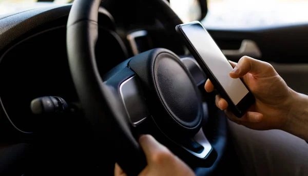 Mann benutzt Smartphone bei Testfahrt im Auto — Stockfoto