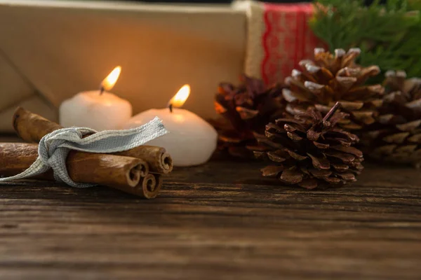 Illuminated candle with pine cones — Stock Photo, Image