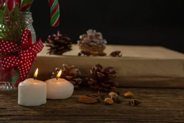 Verlichte kaarsen met dennenappels en geschenkdoos — Stockfoto