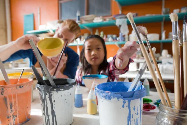 Male potter and girl painting bowl — Stock Photo, Image