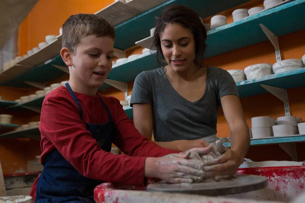 Potter assisting boy in molding a clay — Stock Photo, Image