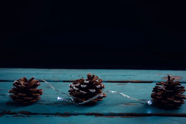 Cône de pin décoré de lumière de Noël — Photo