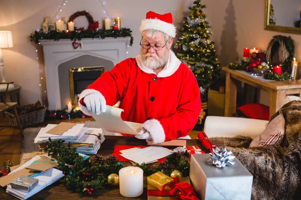 Santa Claus lezing scroll in woonkamer — Stockfoto