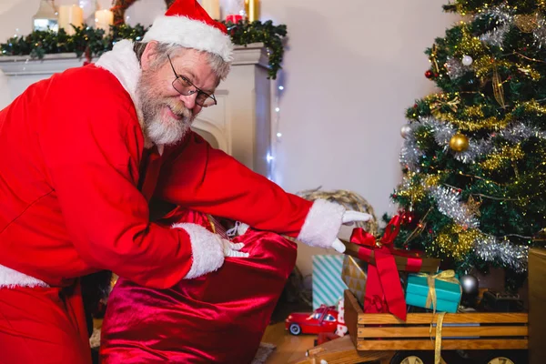 Weihnachtsmann beim Arrangieren von Geschenken — Stockfoto