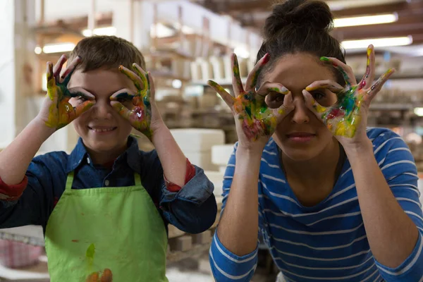 Mother and son gesturing in pottery workshop — Stock Photo, Image