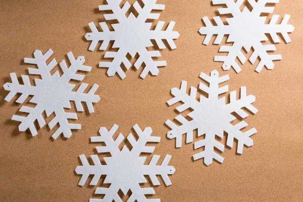 Weiße Schneeflocken auf braunem Hintergrund — Stockfoto