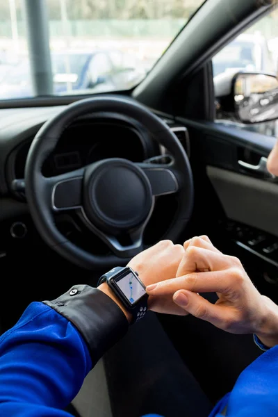Mulher usando relógio inteligente no carro — Fotografia de Stock