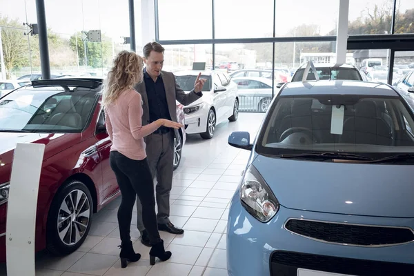 Salesman showing car to female customer — Stock Photo, Image