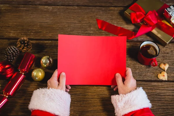 Santa Claus drží červené papíru — Stock fotografie