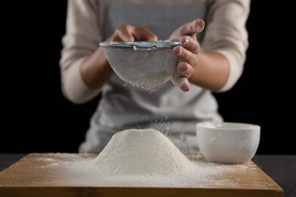 Donna setacciando farina dalla ciotola — Foto Stock