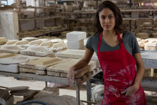 Женщина-гончар, стоящая в мастерской по керамике — стоковое фото