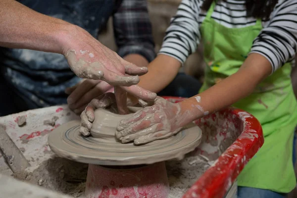 Mannelijke potter dochter bijstaan in het maken van de pot — Stockfoto