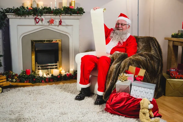 Weihnachtsmann liest Schriftrolle — Stockfoto