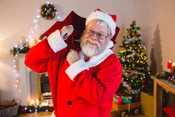 Santa claus holding gåva säck hemma — Stockfoto