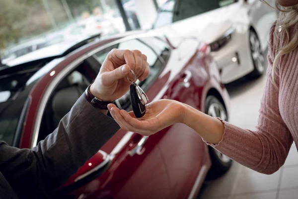 Vendedor dando chaves de carro para cliente feminino — Fotografia de Stock