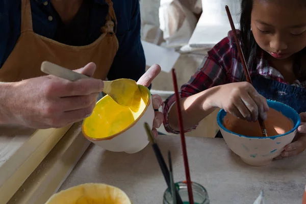 Male potter and girl painting bowl — Stock Photo, Image