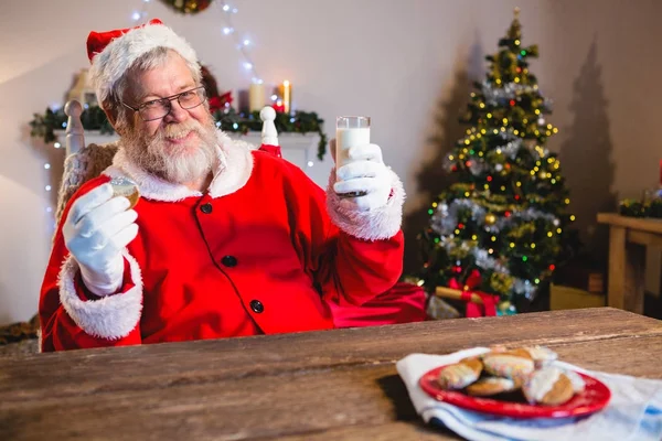Kerstman met cookie met glas melk — Stockfoto