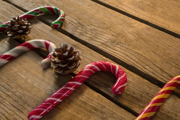 Bastoncini di caramelle colorate con pigne — Foto Stock