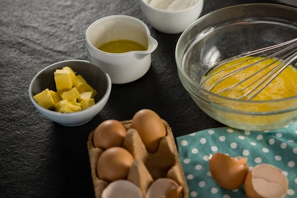 Beaten eggs, egg tray, butter, oil — Stock Photo, Image