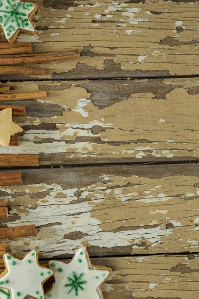 Kerstkoekjes en kaneel houten plank — Stockfoto