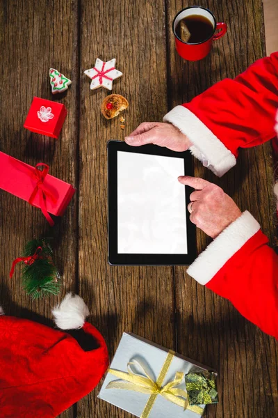 Санта-Клаус с помощью планшета на столе — стоковое фото