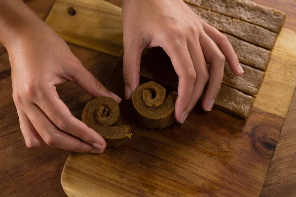 Woman arranging dough on chopping board — Stock Photo, Image