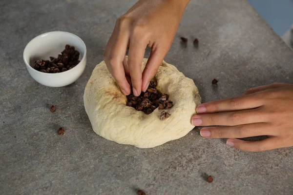 Donna che aggiunge gocce di cioccolato nella pasta — Foto Stock