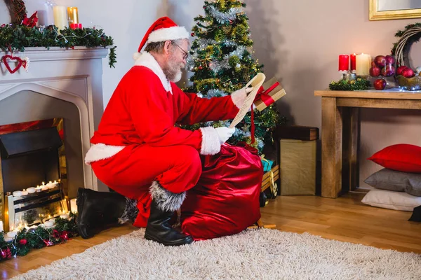 Santa Claus läsning bläddra i vardagsrum — Stockfoto