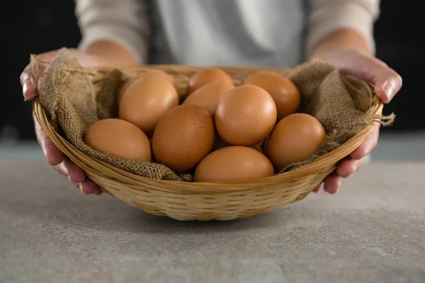 Woman holding basket with brown eggs — Stock Photo, Image