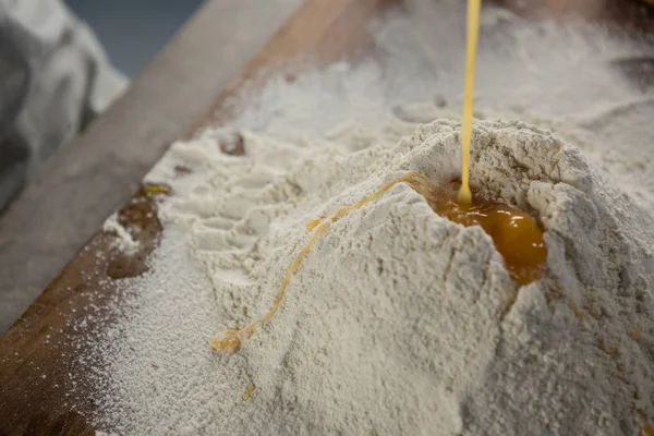 Liquid egg poured on flour — Stock Photo, Image