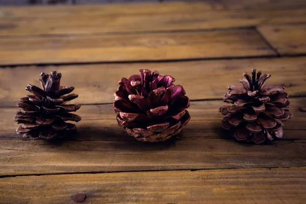 Cônes de pin sur planche de bois — Photo