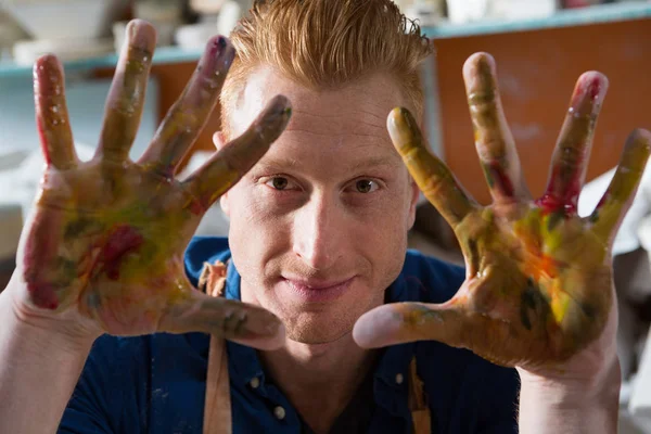 Alfarero macho mostrando sus manos pintadas — Foto de Stock