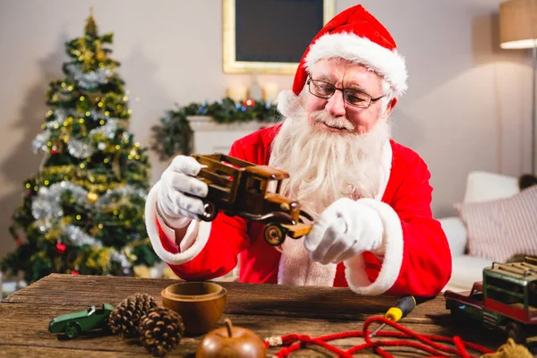 Lächelnder Weihnachtsmann beim Anblick von Spielzeug — Stockfoto