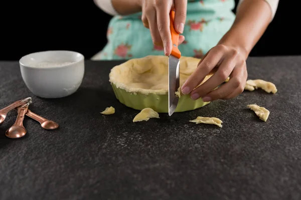 Donna che taglia via la pasta extra dalla muffa — Foto Stock