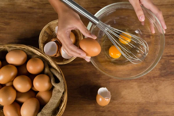 Человек разбивает яйца в миске — стоковое фото