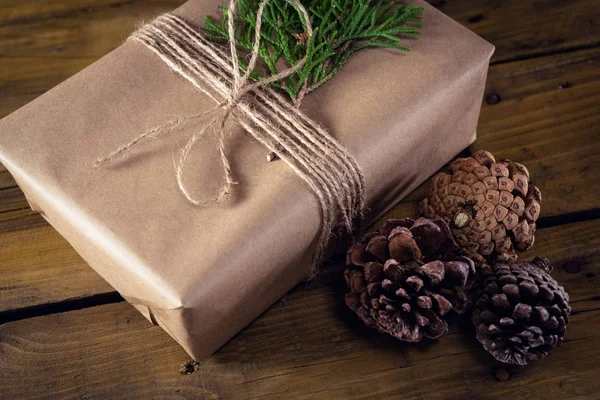 나무 테이블에 선물 상자, 전나무와 소나무 콘 — 스톡 사진