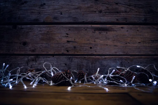Noel ışık ve çam kozalakları — Stok fotoğraf