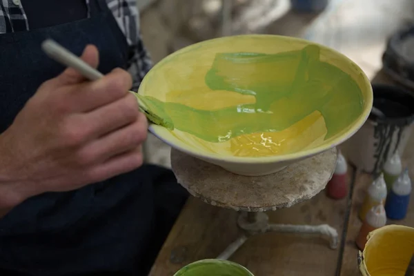 Manliga potters hand måla en skål — Stockfoto