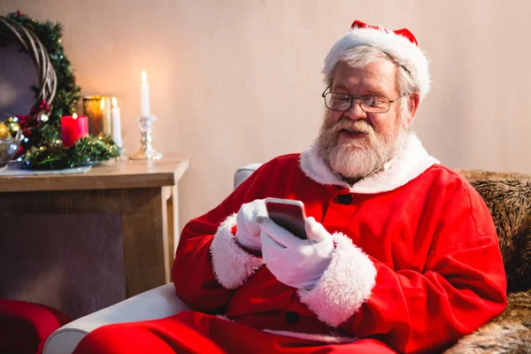 Santa claus siedzi i przy użyciu telefonu — Zdjęcie stockowe