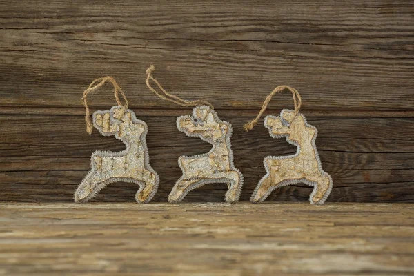 Reindeer decorations against wooden plank — Stock Photo, Image