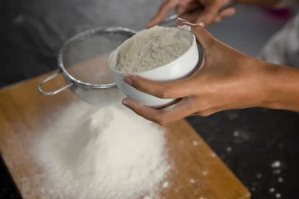 Woman sieving flour from bowl — Stock Photo, Image